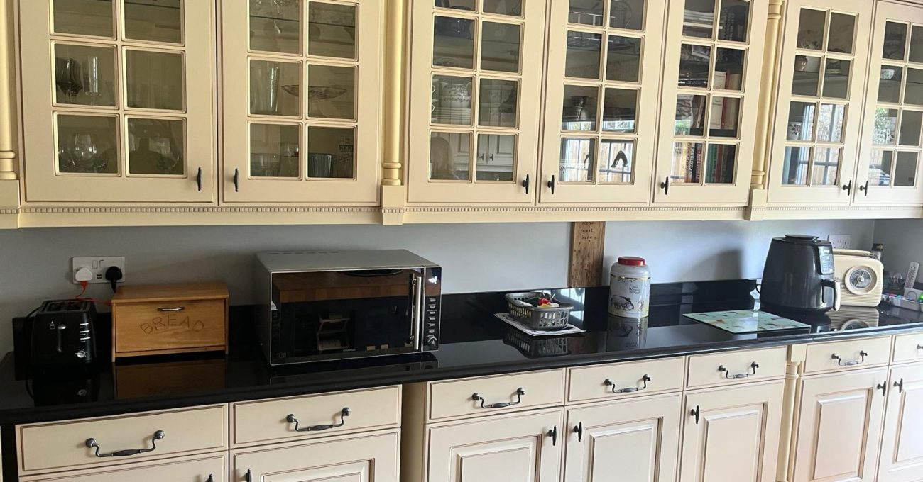 Original leaded-glass wall cabinets and cream door frontals in Yateley, Hampshire before the kitchen door replacement