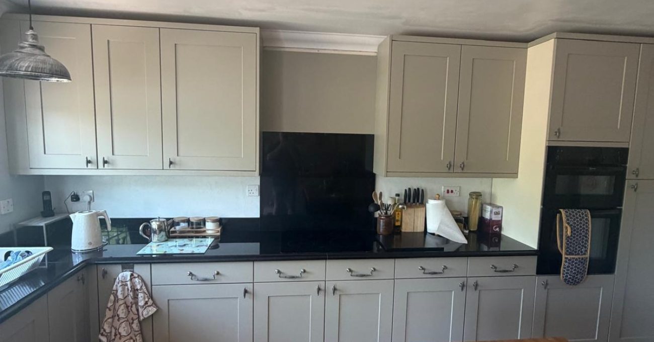 Completed kitchen in Yateley, Hampshire showing the full run of new Riva painted frontals and retained black granite worktops