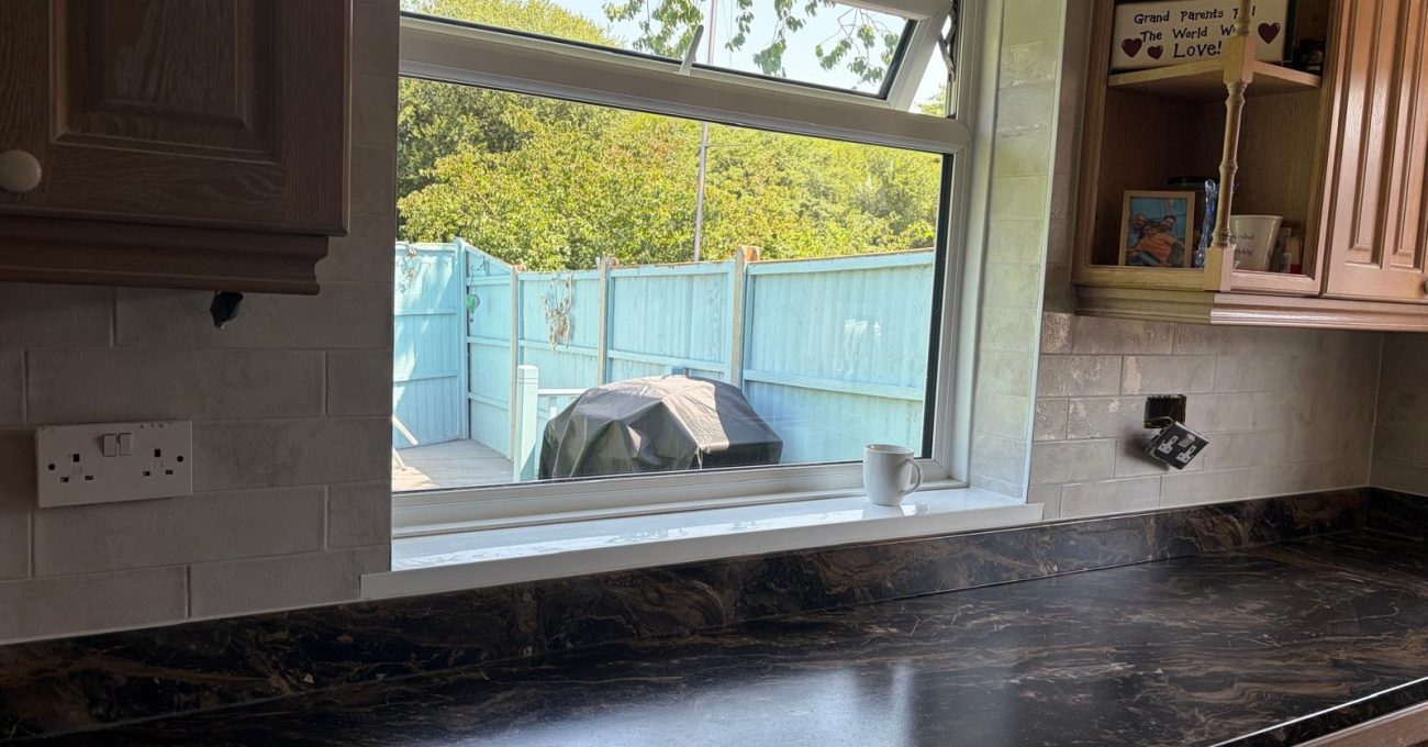 Refreshed kitchen in Blackwater, Surrey with new marbled laminate worktop and pale stone-effect wall tiles