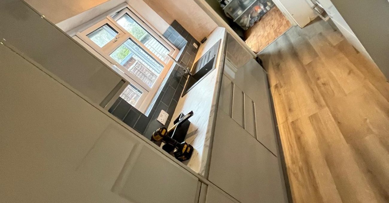 New galley kitchen in Guildford, Surrey with gloss painted Portofino units and wood-effect LVT flooring