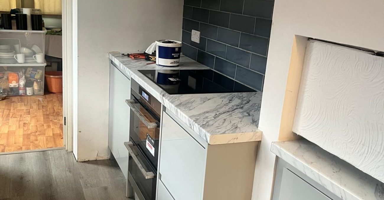 New Portofino kitchen in Guildford, Surrey with integrated oven, induction hob and marble-effect worktop