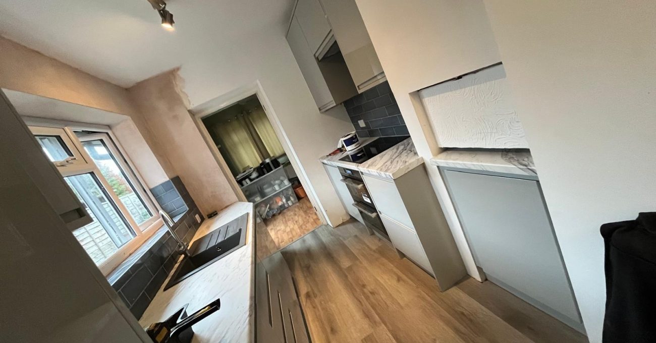 Full view of the completed galley kitchen in Guildford, Surrey replacing a water damaged room