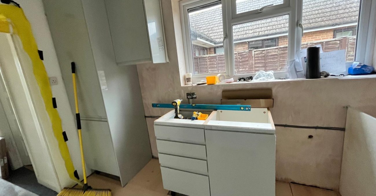 New kitchen carcasses being installed in Guildford, Surrey against freshly plastered walls