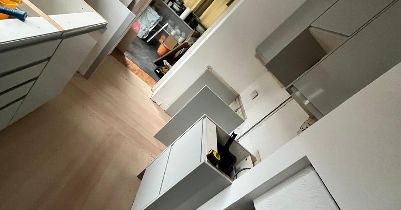 Kitchen installation in progress in Guildford, Surrey with wall and base units being levelled