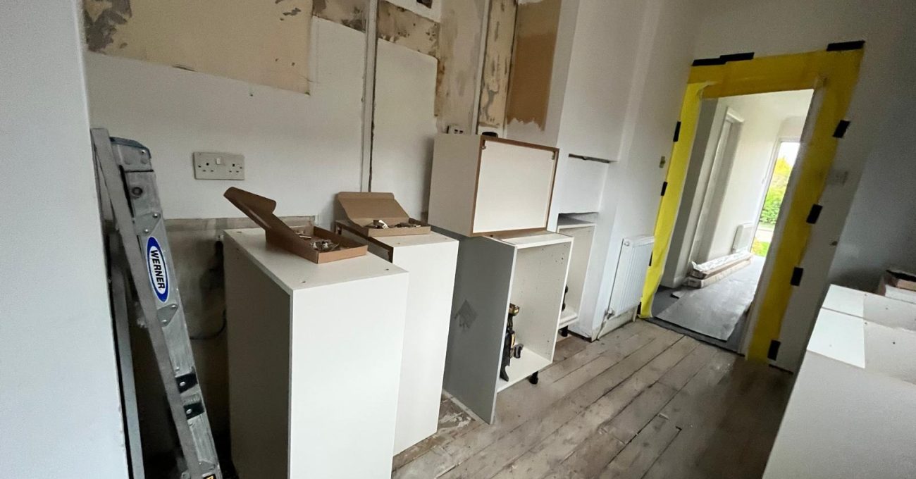 Kitchen units being fitted in Guildford, Surrey after water damage repairs and replastering