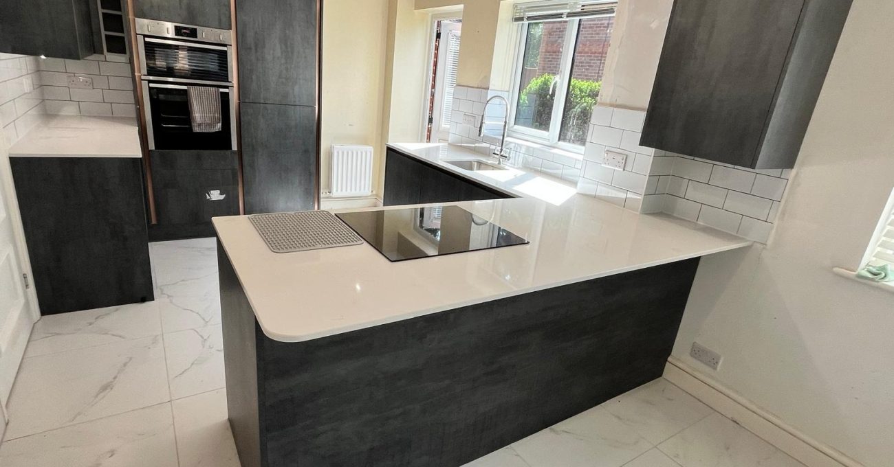 Completed Linear for Vero kitchen in Sandhurst, Berkshire with island hob, stone worktop, integrated ovens and metro tile splashback