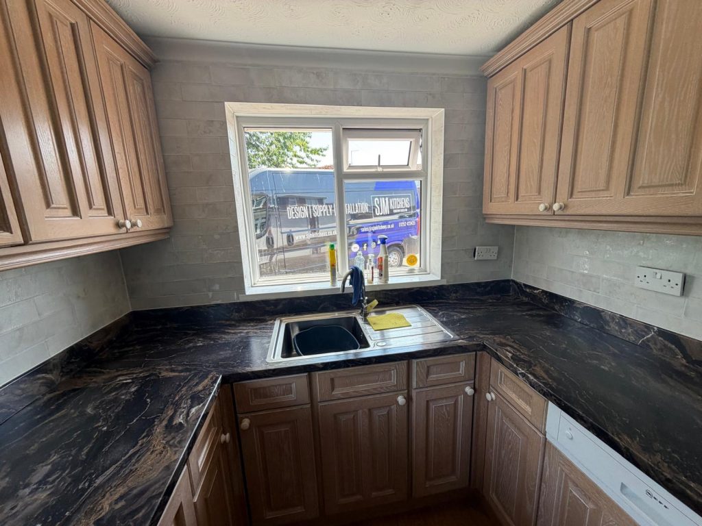 Completed U-shaped kitchen refresh in Blackwater, Surrey with new worktops, wall tiles and flooring by SJM Kitchens