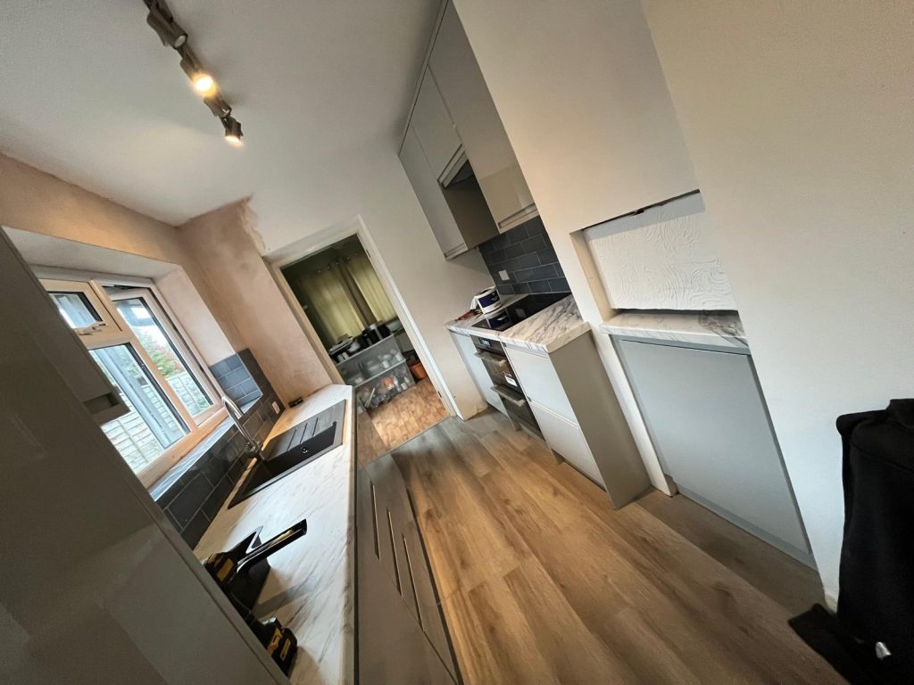 Full view of the completed galley kitchen in Guildford, Surrey replacing a water damaged room